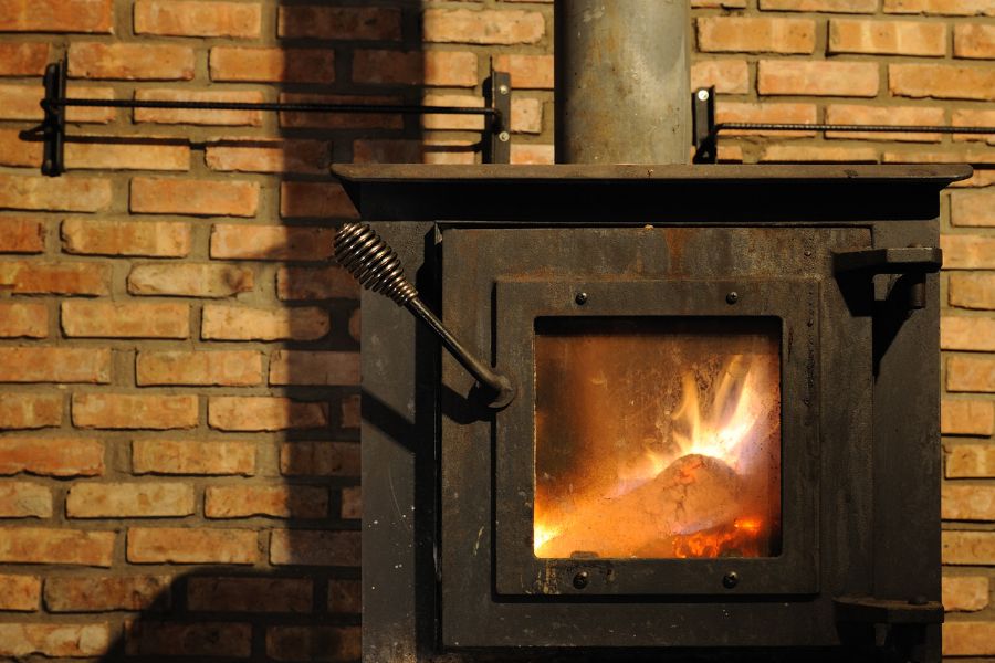 A fire burns in metal wood stove
