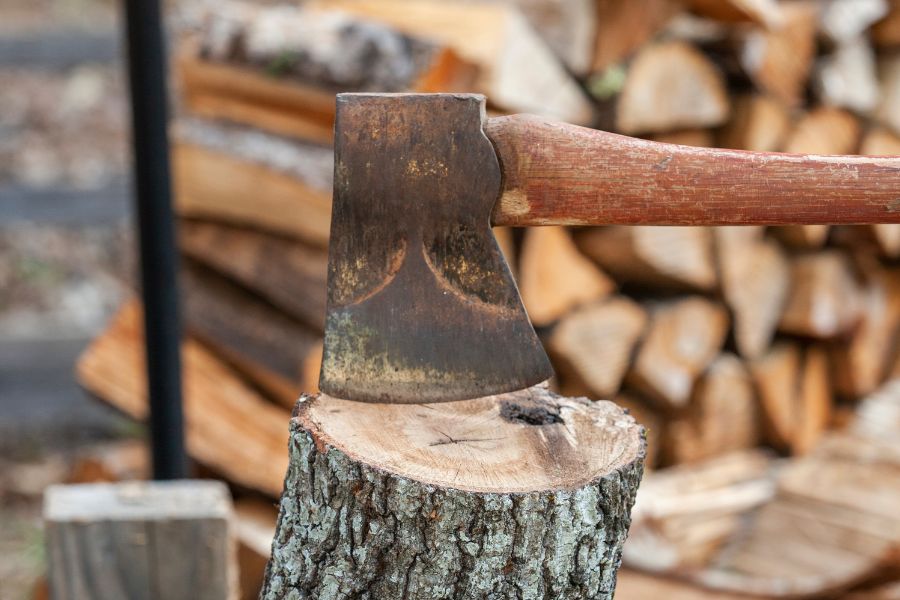 An axe splitting wood log for firewood