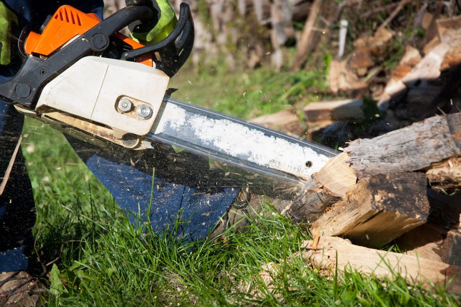 Man cutting firewood with chainsaw