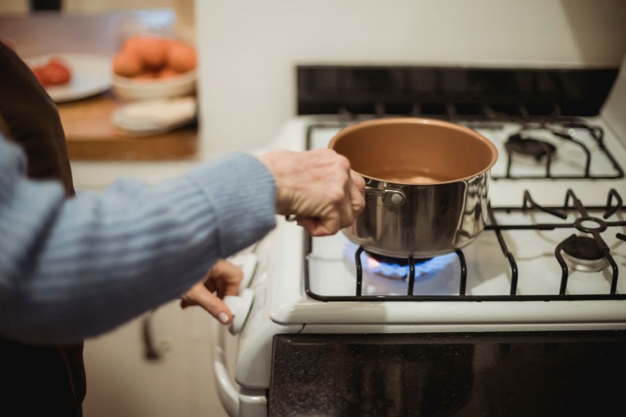 Woman cooking on gas stove with medium heat