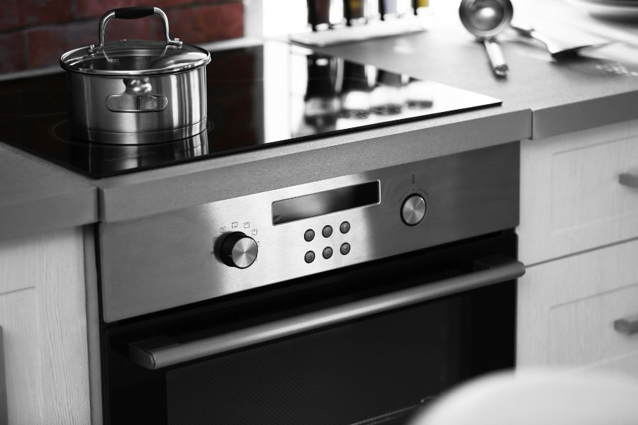 Modern electric stove with saucepan