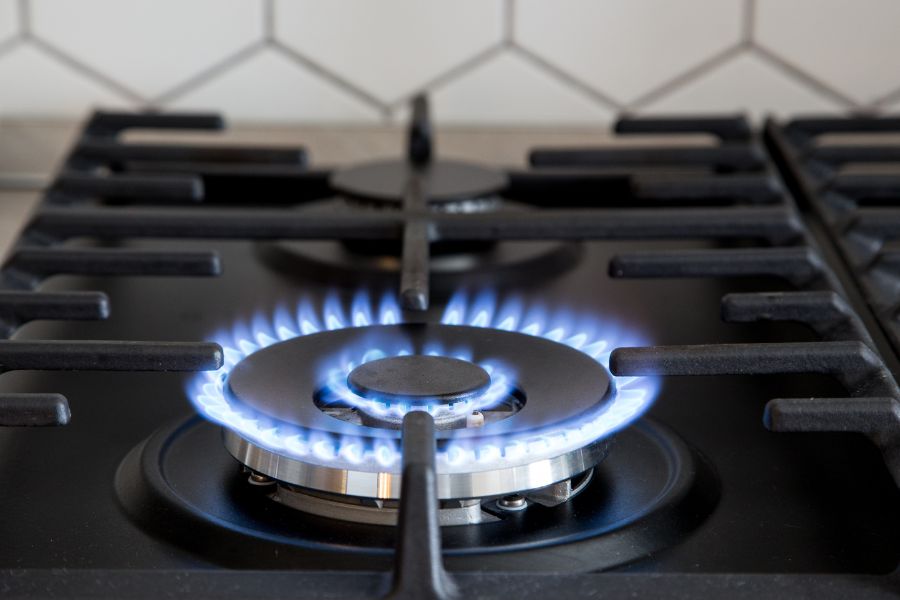 Gas burner with flame on black stove