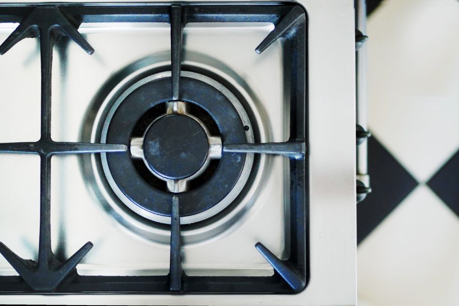Top view of white gas stove with cast iron grates