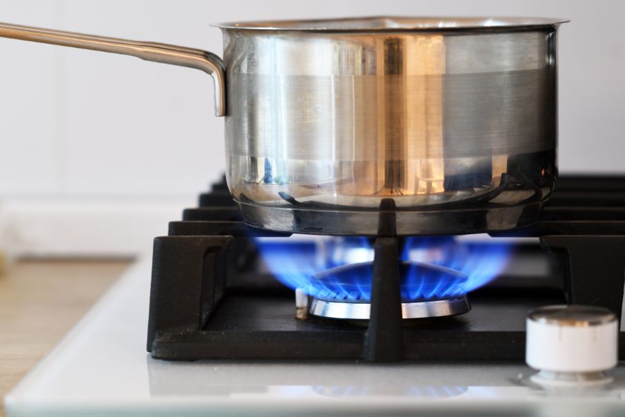 A pot on gas stove with high grates