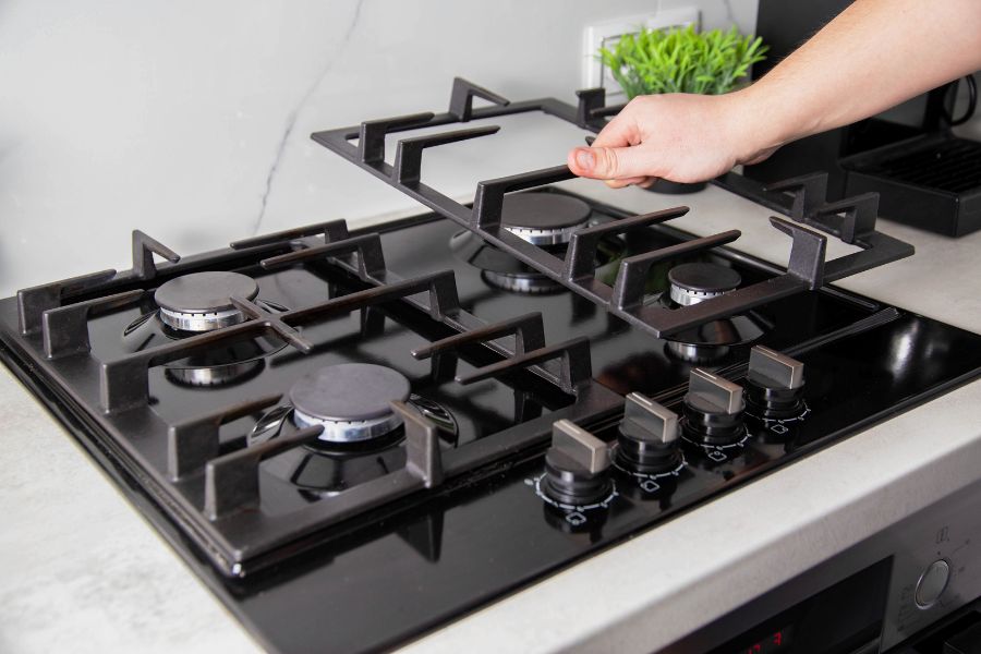 Hand removing gas stove grates