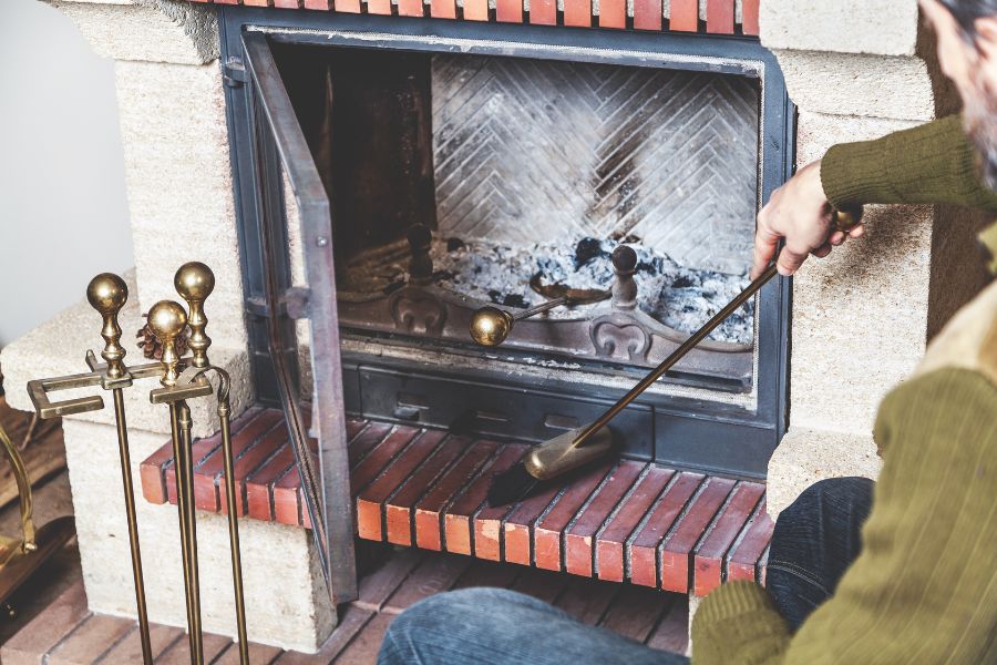 Man cleaning fireplace with brush