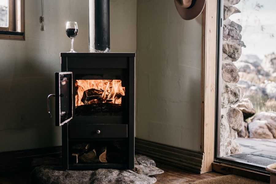 Wood burning stove on corner side of a house