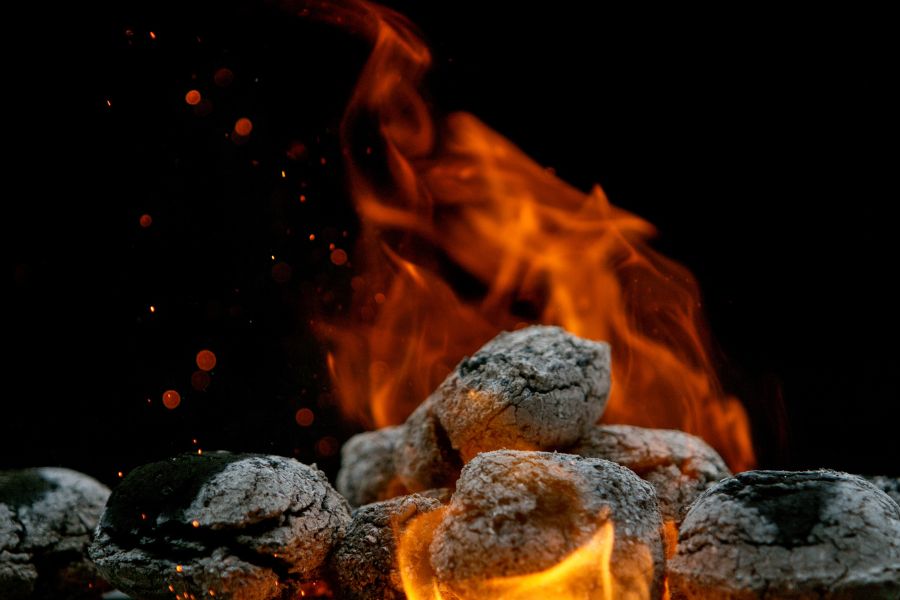 Close-up burning charcoal briquettes
