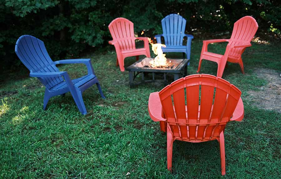 Tables arount a fire pit on grass