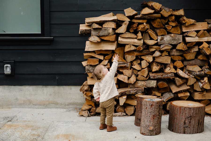 Child behind elm firewood stack