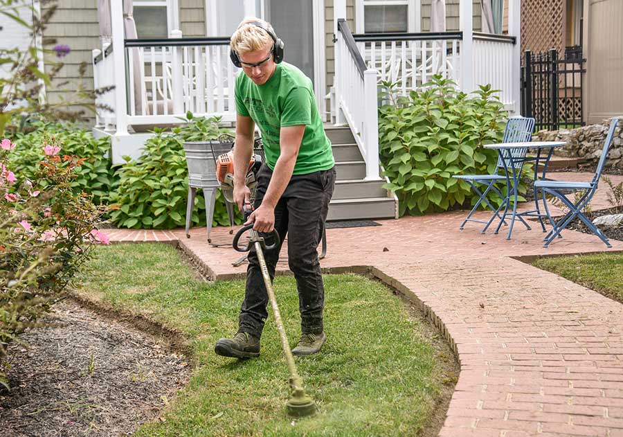 trimming the grass in the designated fire pit space