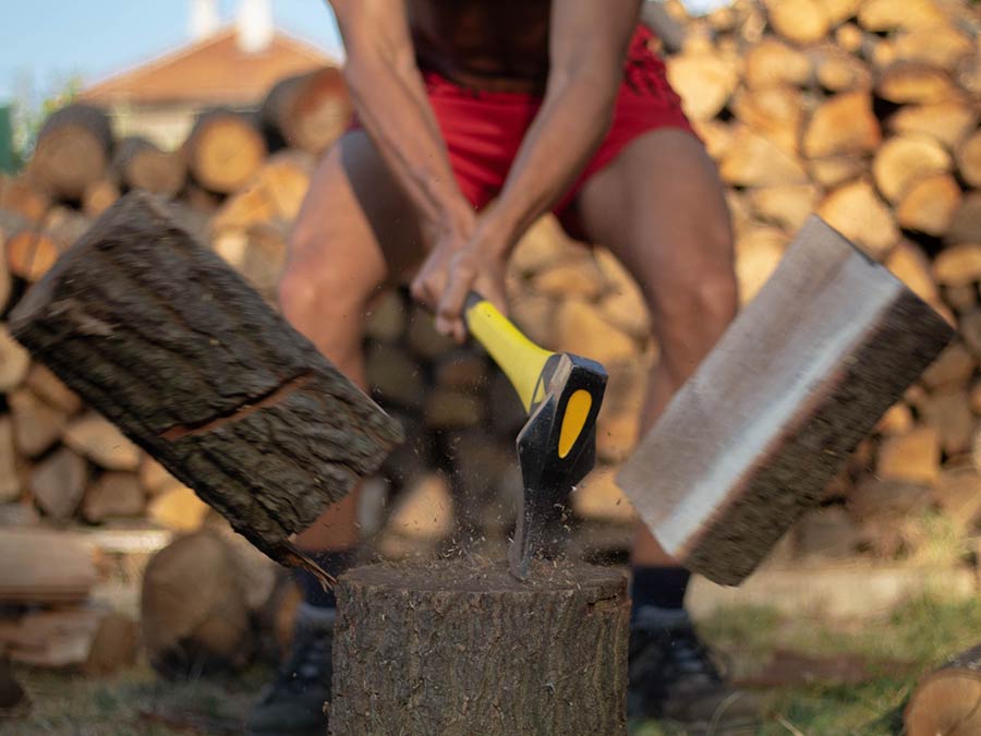 Man use axe to split wood
