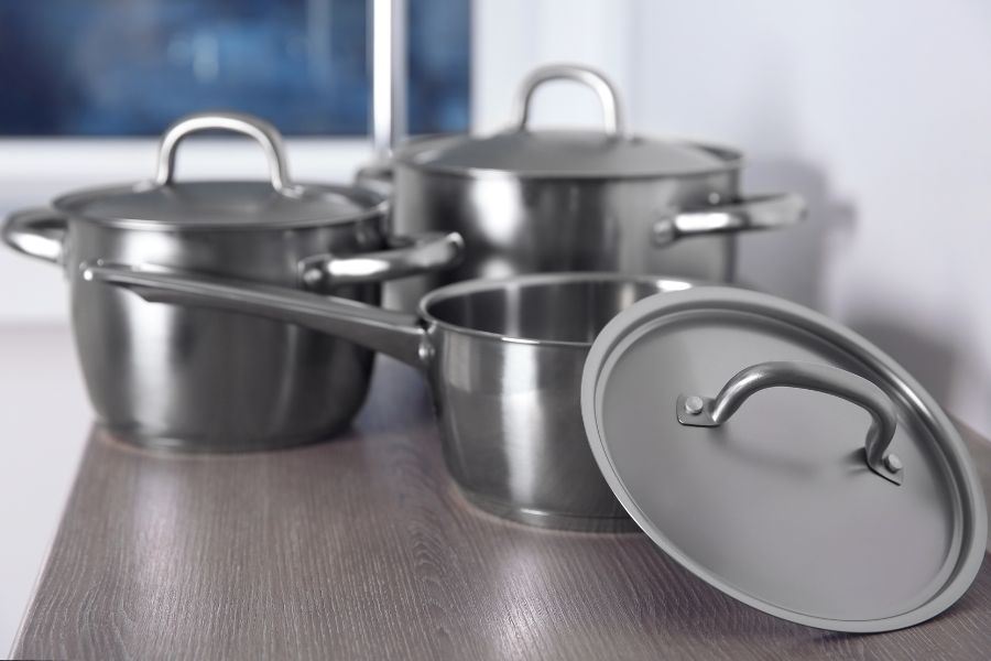 Set of stainless steel cookware on table