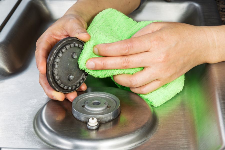 Cleaning gas stove burner head with cleaning cloth
